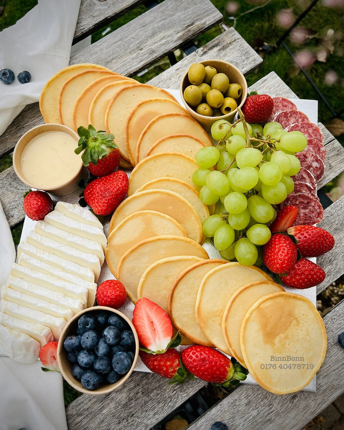 Pancake-Board mit Käse Salami Oliven und verschiedenen Früchten